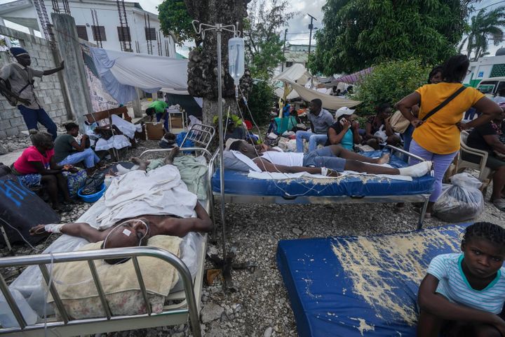 Injured people lie in beds outside the Immacul&eacute;e Conception hospital in Les Cayes, Haiti, on Aug. 16, 2021.