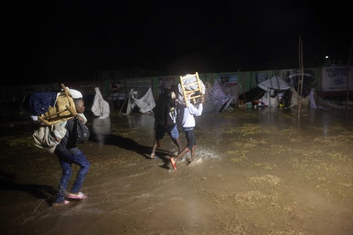 People leave as Tropical Storm Grace hits a refugee camp at a football field called Parc Lande de Gabion after a 7.2-magnitud