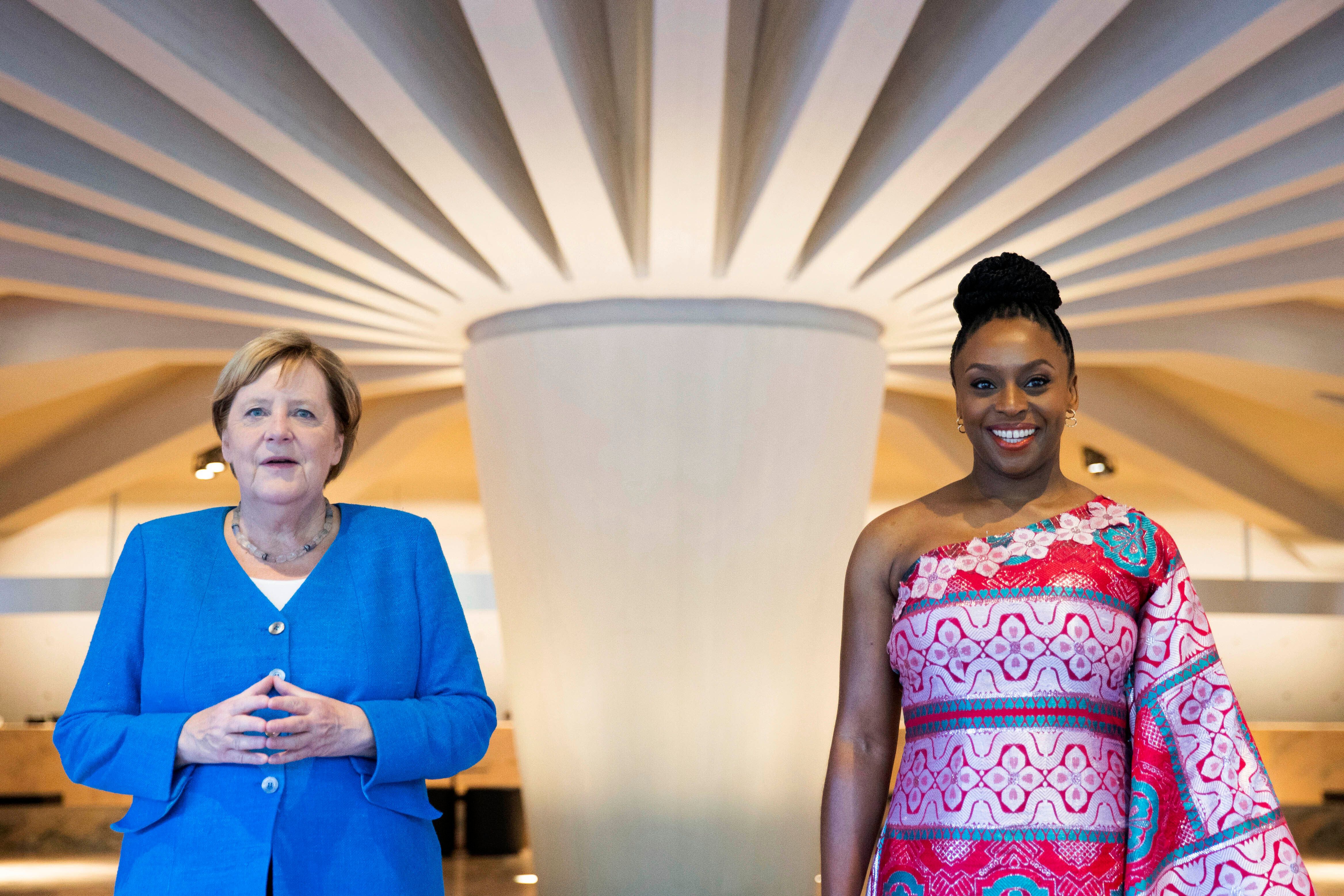 German Chancellor Angela Merkel, left and Nigerian author Chimamanda Ngozi Adichie, stand, prior to taking part in a panel discussion in Duesseldorf, Germany, Wednesday, Sept. 8, 2021. The event was planned for the festival opening of Theater der Welt 2020 (Theatre Of The World 2020) but then postponed by a year due to the Corona pandemic. (Rolf Vennenbernd/Pool Photo via AP