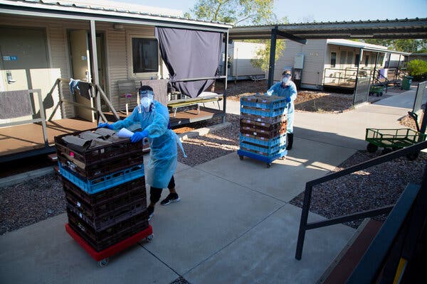 Workers delivering dinner. They work in only one block of the quarantine facility at a time to minimize the risk of spreading infection.