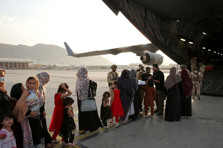 Afghans prepare to to be evacuated aboard a Qatari transport plane, at Hamid Karzai International Airport in Kabul, Afghanist
