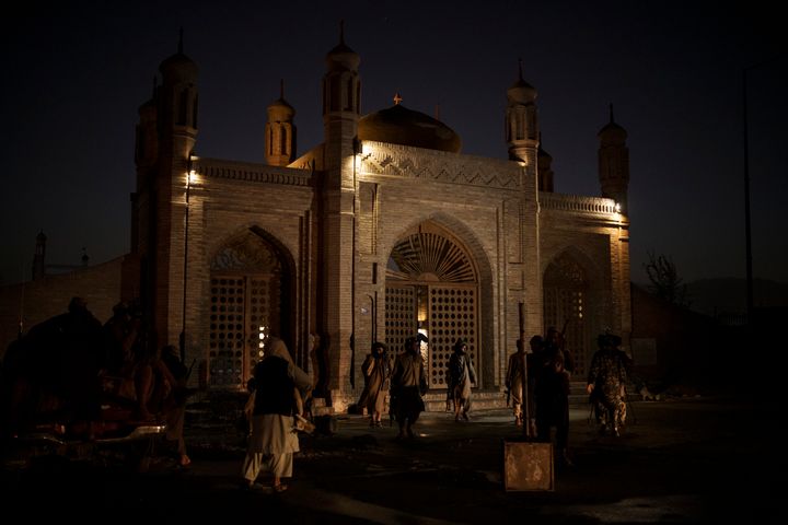 Taliban fighters walk at the entrance of the Eidgah Mosque after an explosion in Kabul, Afghanistan, Sunday, Oct. 3, 2021. A 