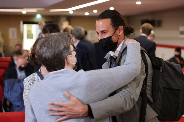 Olivier Savignac, right, one of the victims, greets an attendee during the publishing of a report by an independant commissio