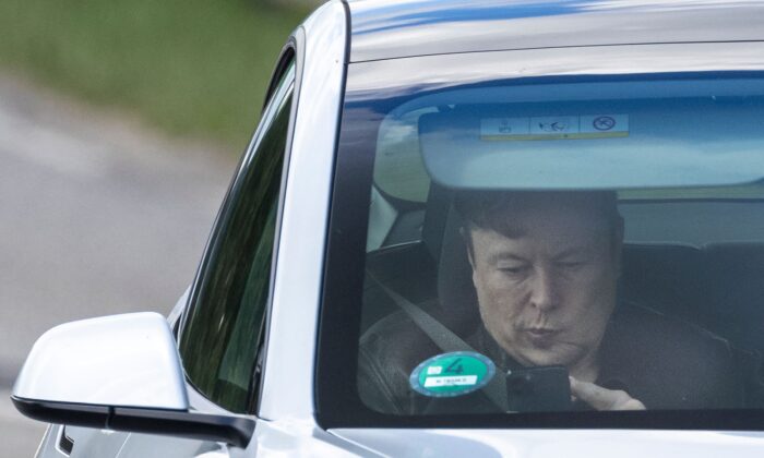 Tesla CEO Elon Musk uses his mobile device as he sits in the car arriving to the construction site for the new plant, the so-called "Giga Factory", of U.S. electric carmaker Tesla in Gruenheide near Berlin, northeastern Germany, on May 17, 2021. (ODD ANDERSEN/AFP via Getty Images)
