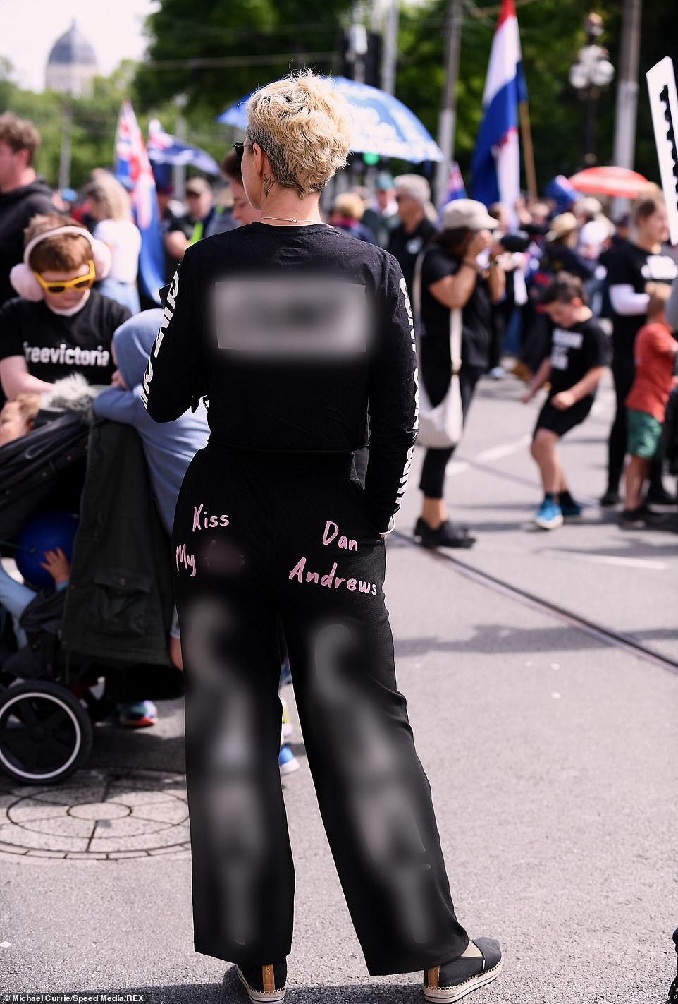 A protester was dressed in an outfit riddled with expletives reading 'Kiss my a** Dan Andrews' and 'C***t' written head to toe