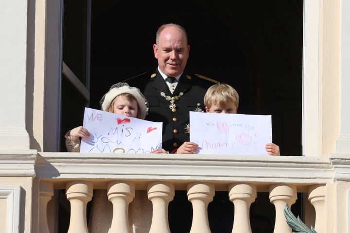 Princess Gabriella and Prince Jacques hold a message for their mother, Princess Charlene, at the balcony of Monaco Palace during the celebrations marking Monaco's National Day on Nov. 19, 2021.