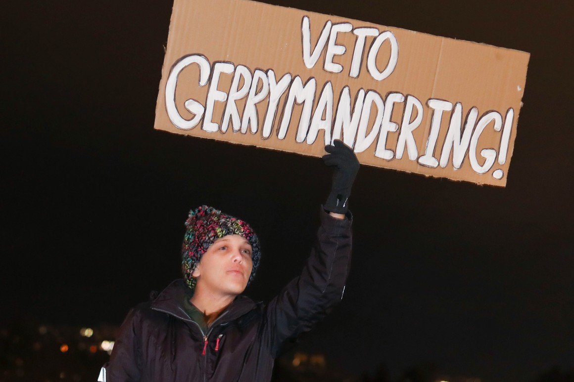 A Utah rally-goer holds a sign that reads &quot;veto gerrymandering.&quot;