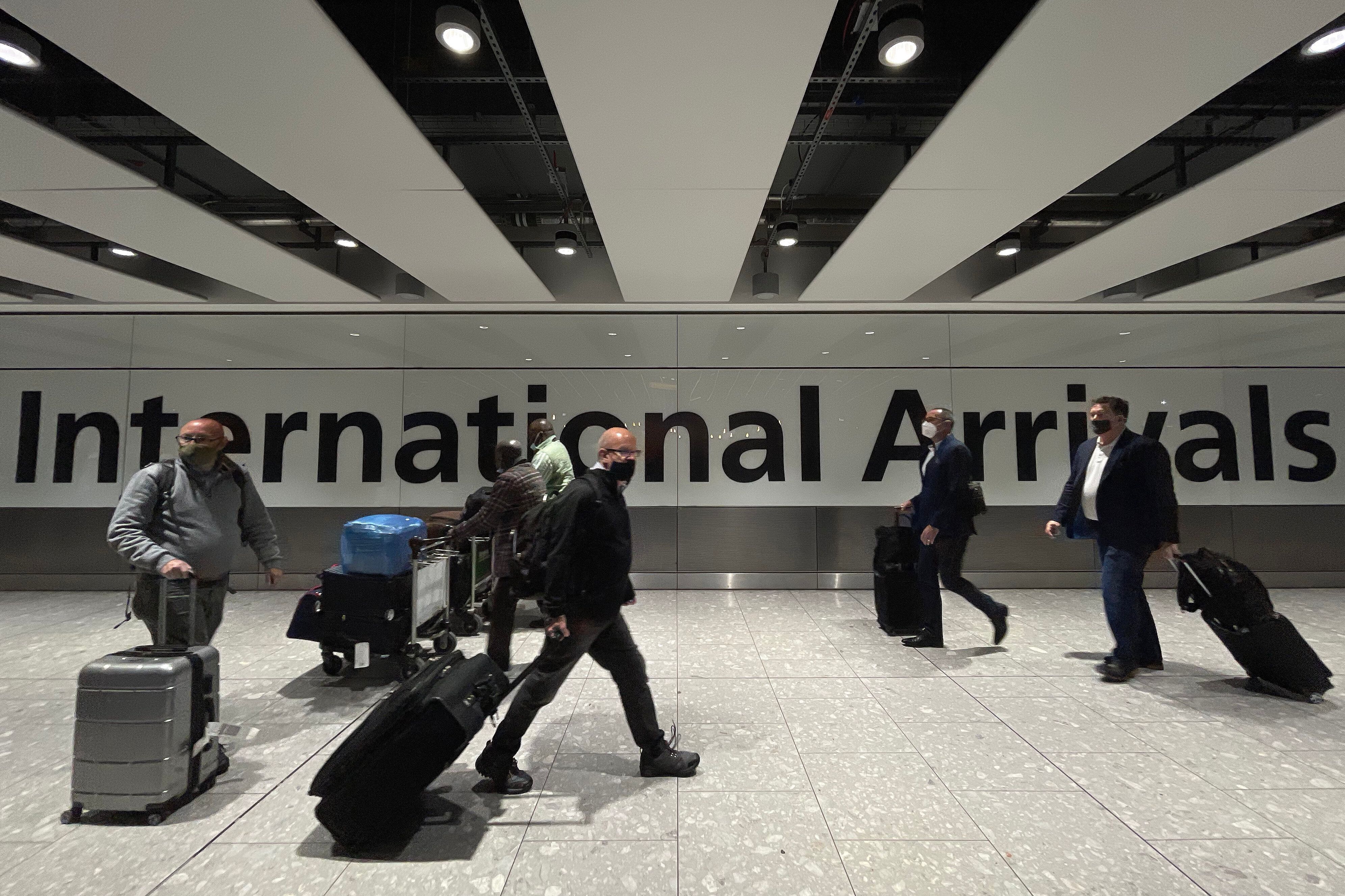 International passengers walk through the arrivals area at Terminal 5 at Heathrow Airport on November 26, 2021 in London, England. (Photo by Leon Neal/Getty Images)