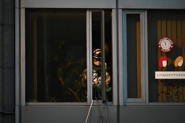 A firefighter works inside an office building where a fire broke out in Osaka on December 17,2021. (Photo by Philip FONG / AFP) (Photo by PHILIP FONG/AFP via Getty Images)