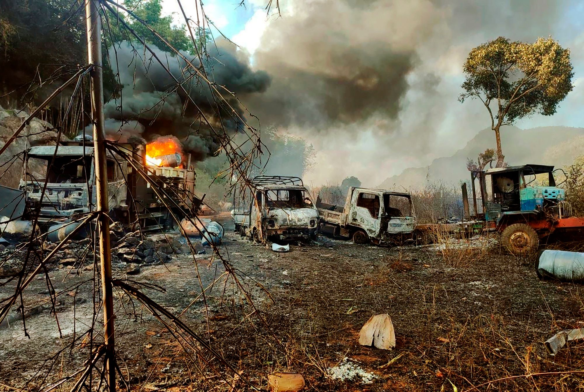 In this photo provided by the Karenni Nationalities Defense Force (KNDF), smokes and flames billow from vehicles in Hpruso township, Kayah state, Myanmar, Friday, Dec. 24, 2021. (KNDF via AP)