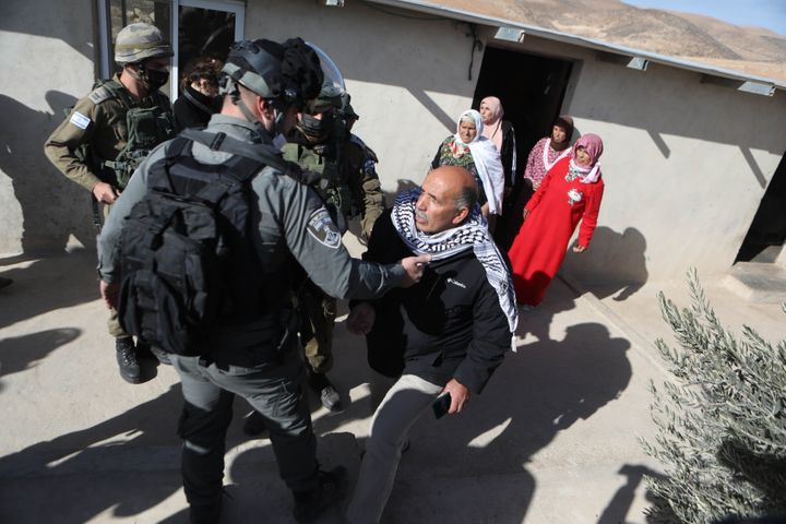 Israeli forces confront a Palestinian family whose home they say is "unlicensed" in Hebron, West Bank, on Jan. 12, 2021.