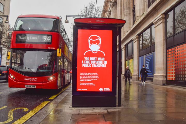 A display is seen on a bus stop on Oxford Street in London that informs people that they must wear a face covering on public transport as the Omicron variant of coronavirus continues to spread.