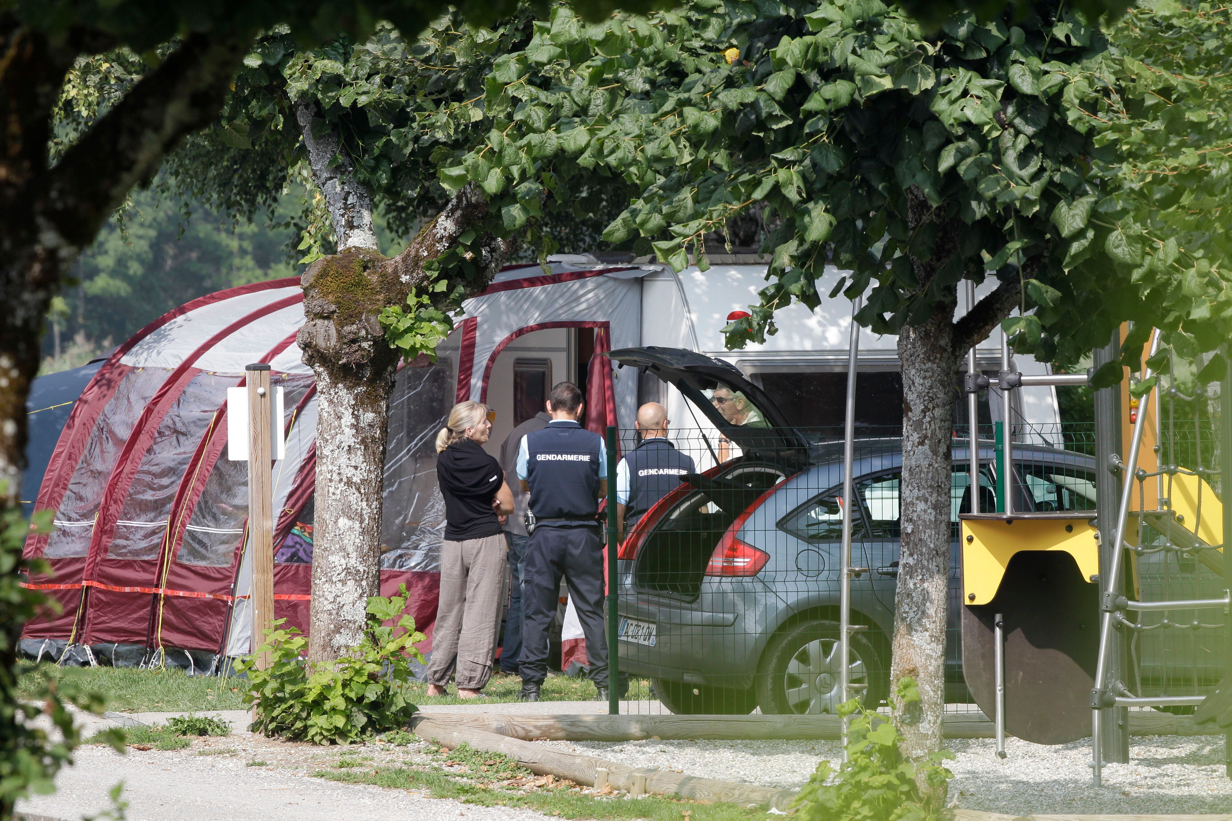 Gendarmes and investigators stand at the camp site where a slain British family were on vacation in Saint Jorioz, near Annecy, on Sept. 6, 2012. (AP Photo/Lionel Cironneau, File)