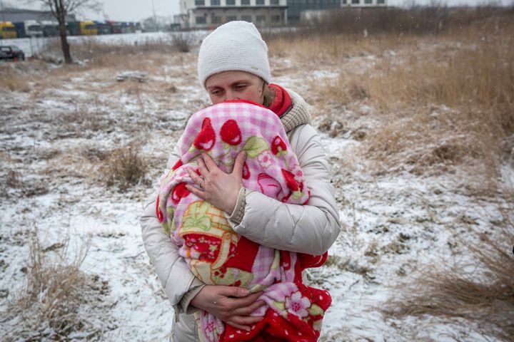 Axana Opalenko, 42, holds Meron, 2 months old, in an effort to warm him after fleeing from Ukraine, at the border crossing in Medyka, Poland, Wednesday, March 9, 2022. U.N. officials said that the Russian onslaught has forced 2 million people to flee Ukraine. It has trapped others inside besieged cities that are running low on food, water and medicine amid the biggest ground war in Europe since World War II.