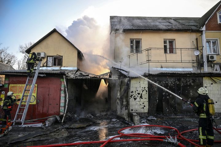 Firefighters extinguish a fire on a house after shelling in Kyiv.