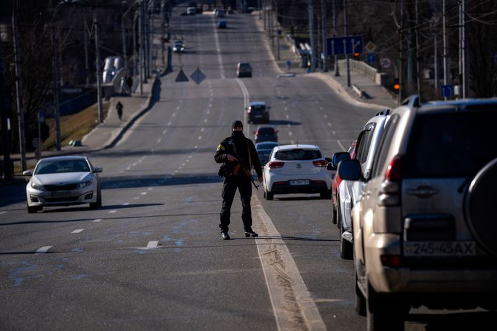 A police officer stands guard at a road leading to central Kyiv, Ukraine, Monday, Feb. 28, 2022. (AP Photo/Emilio Morenatti)
