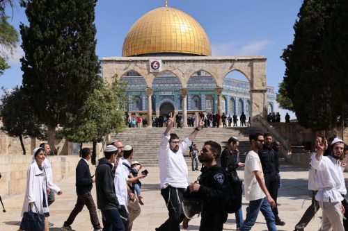 Israeli police accompany a group of Jewish visitors past the Dome of the Rock mosque at the al-Aqsa mosque compound in the Old City of Jerusalem on May 5, 2022 [AHMAD GHARABLI/AFP via Getty Images]