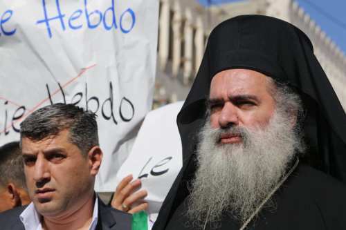 Bishop Atallah Hanna with Palestinian men take part in a protest against satirical French weekly magazine Charlie Hebdo's cartoons of the Prophet Mohammad, in the West bank city of Hebron on 22 January 2015. [Muhesen Amren-Apaimages]