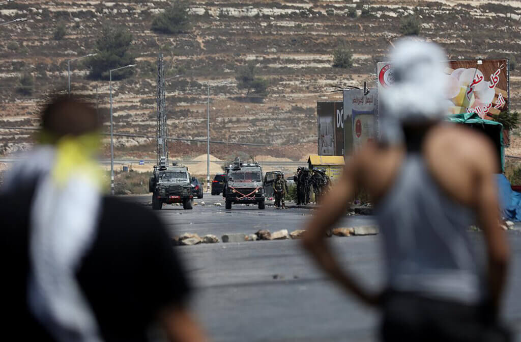 Palestinian protesters clash with Israeli troops following a protest in a solidarity with the Gaza Strip, near the Beit El settlement near the West Bank city of Ramallah, on August 6, 2022. Photo by WAFA