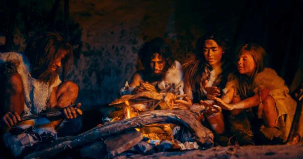 Neanderthal or Homo Sapiens family cooking animal meat over a fire.	Source: Gorodenkoff/Adobe Stock
