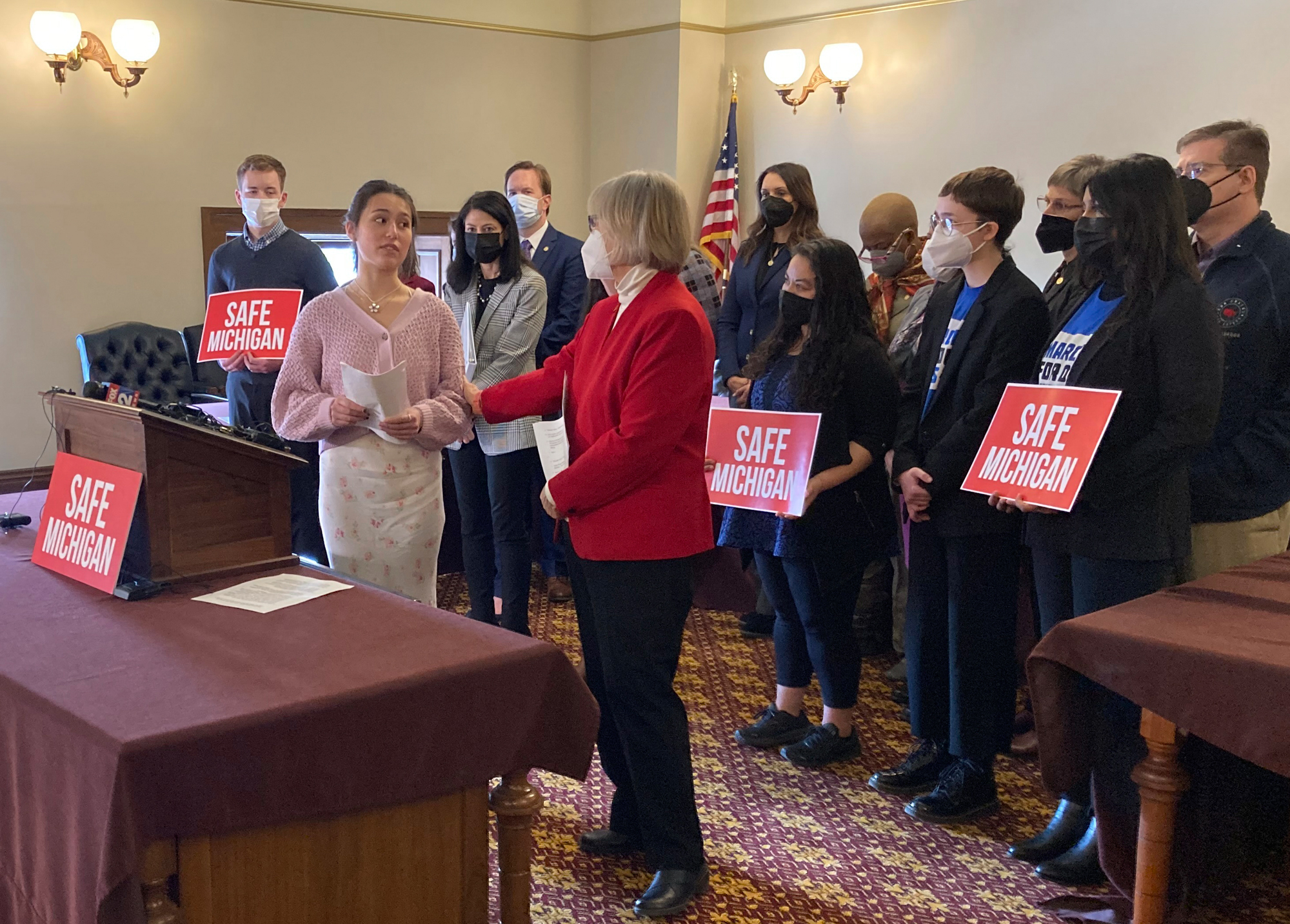 Reina St. Juliana, a student at Oxford High School, thanks Sen. Rosemary Bayer, front right, for sponsoring a bill for safe gun storage, during a news conference Feb. 15, 2022, in the state Capitol in Lansing, Mich. Reina's sister, Hana, was killed in a mass shooting at the school.