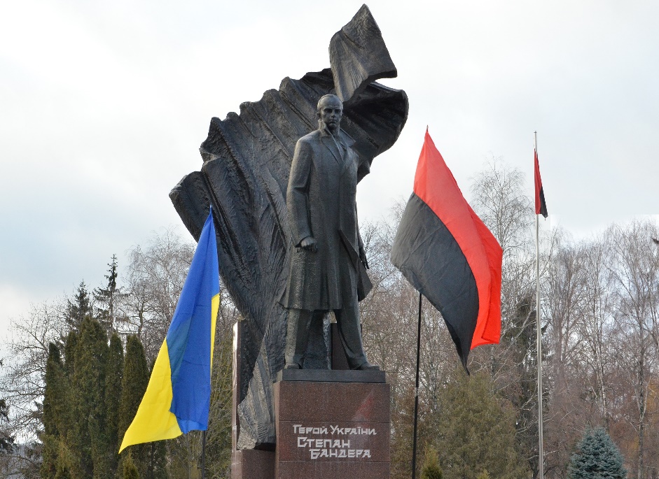 A statue of a person holding a flag and a flag Description automatically generated with low confidence