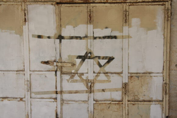 A shuttered Palestinian shop in Hebron closed down by the Israeli military that was vandalized with a Star of David, an ancient Jewish symbol adopted by the Israeli state as a national symbol. (Photo: Lauren Surface)