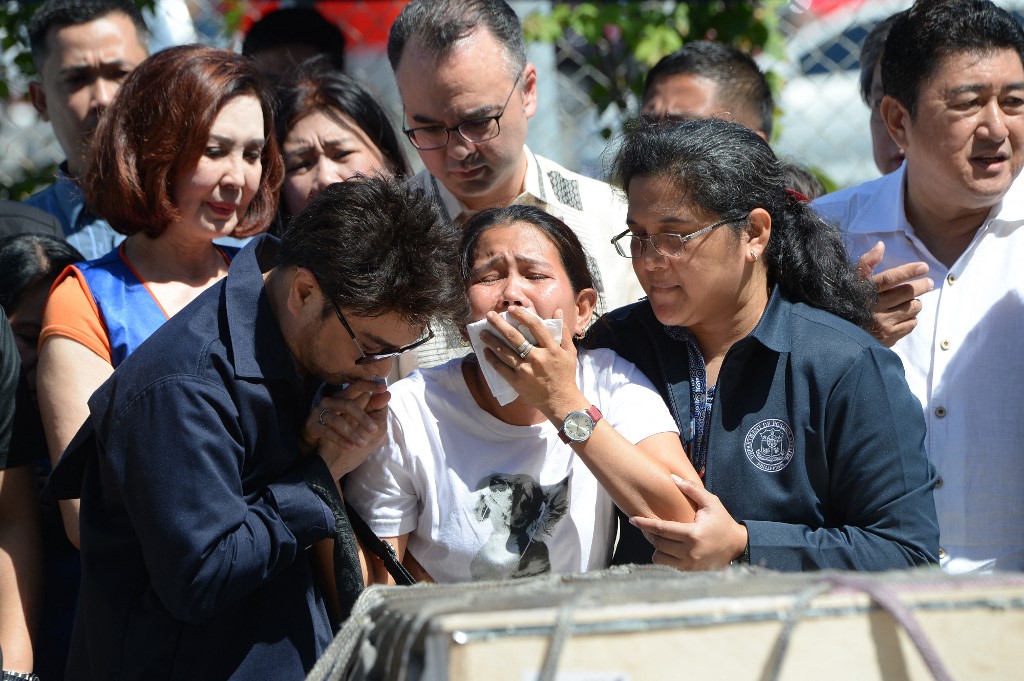 Jessica, sister of Filipina overseas worker Joanna Demafelis whose body was found inside a freezer in Kuwait, cries in front of a wooden casket containing her sister's body shortly after its arrival at the international airport in Manila on February 16, 2018.
