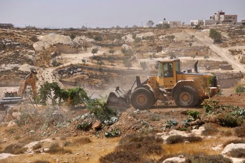 An Israeli bulldozer demolishes a Palestinian agricultural piece of land in area "C", in the West Bank town of Hebron, on August 25, 2021 [HAZEM BADER/AFP via Getty Images]