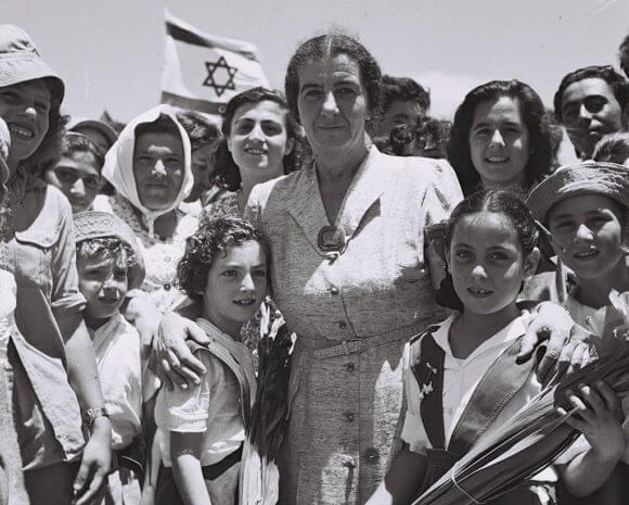 Golda Meir poses with a picture with the children of Kibbutz Shefaim, July 24, 1950 (Photo: Wikimedia)