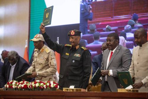 Head of Sudan’s ruling Sovereign Council and Commander-In-Chief of the Sudanese Armed Forces Abdel Fattah al-Burhan (C) and his Deputy Mohamed Hamdan Dagalo (L) attend the ceremony held at the Friendship Congress and Meeting Hall in Khartoum, Sudan on December 05, 2022 [Mahmoud Hjaj/Anadolu Agency]