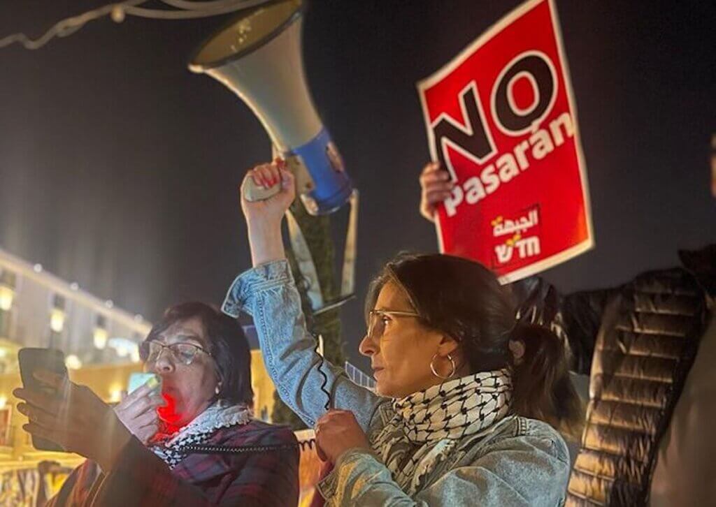 Reem Hazzan holding a megaphone at a protest in Haifa. (Photo: Hadash - Democratic Front for Peace and Equality - Haifa)