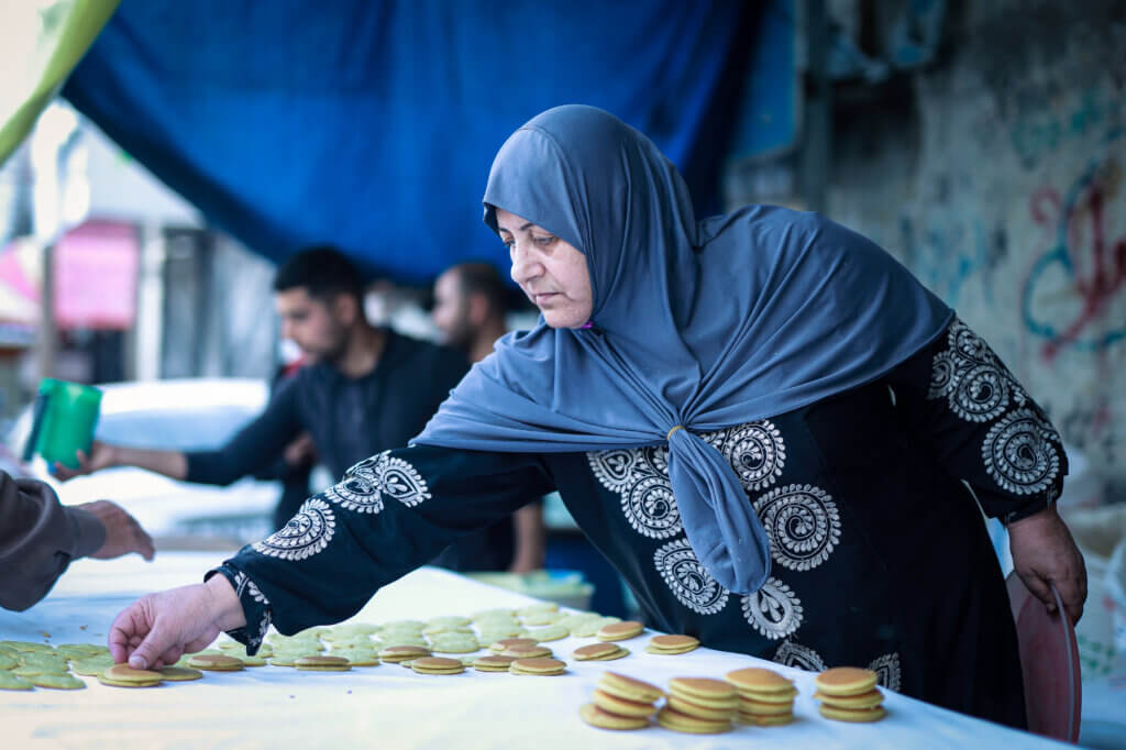 Mariam Salha prepares the Ramadan dessert qatayef to sell near the entrance of Deir al-Balah refugee camp in Gaza city. (Photo: Mohammed Salem, Mondoweiss)