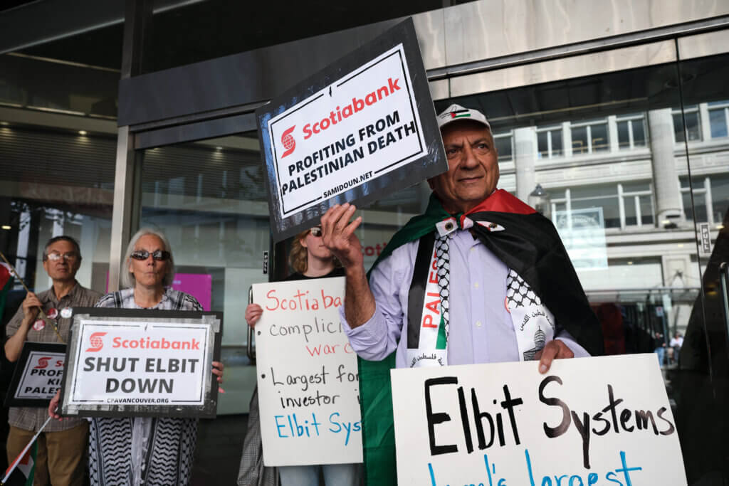 Palestine solidarity activists hold posters and signs in Vancouver Canada during a rally outside the Scotiabank Towers to protest the bank's investment in Elbit Systems, June 3, 2023. (Photo: Michael YC Tseng)