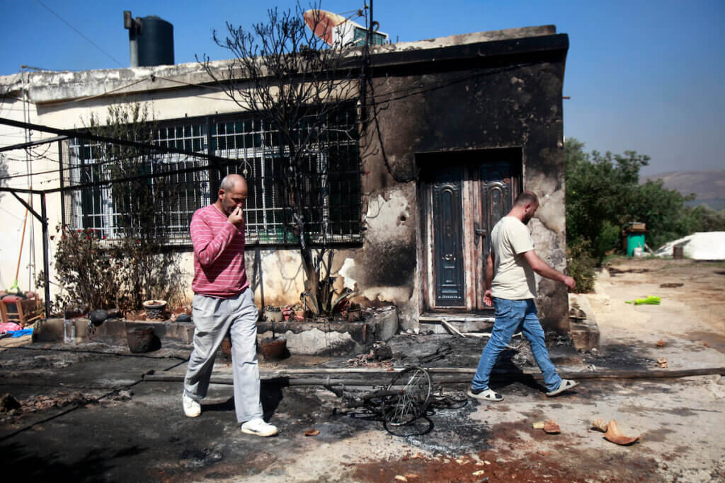 Palestinians inspect a house set on fire by Israeli settlers in the Palestinian village of Turmus Aya, near Ramallah, June 21, 2023. The photo portrays the charred remains of one of the houses, as Palestinians walk by it and inspect the level of destruction.