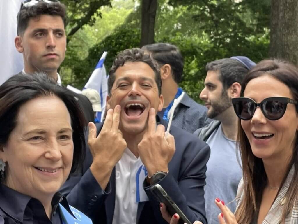 Amichai Chikli, minister of diaspora affairs in the Netanyahu government, makes an obscene gesture toward demonstrators during Celebrate Israel Parade, June 4, 2023, in New York. At left is Rebecca Caspi a vice president of the Jewish Federations. Photo from UnXeptable, a liberal Zionist organization.