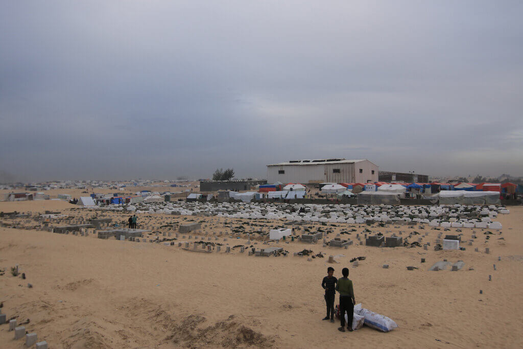 Palestinians who migrated to southern Gaza due to Israeli attacks, struggle to live under difficult conditions in makeshift tents they set up around a cemetery in Rafah, Gaza on February 14, 2024. (Photo: Saeed Jaras/APA Images)
