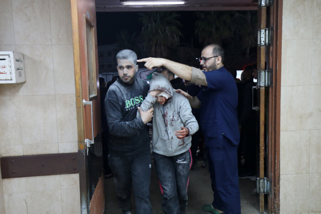 Injured Palestinains covered in dust enter the Al-Aqsa Martyrs Hospital in Deir al-Balah in the central Gaza Strip following Israeli airstrikes on homes in the area.