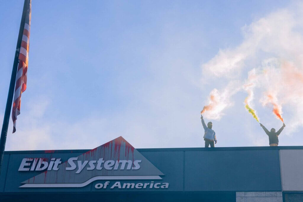 Activists from Palestine Action stand on the roof of an Elbit Systems office in New Hampshire sending up colorful flares. (Photo: Maen Hammad)